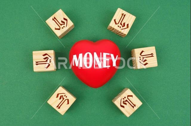 Finance concept. On a green surface, a heart with the inscription - money and cubes with the symbol of the real of saudi arabia Finance concept. On a green surface, a heart with the inscription - money and cubes with the symbol of the real of saudi arabia