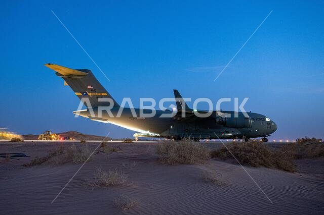 طائرة نقل عسكرية من طراز C-17 غلوب ماستر III تابعة لسلاح الجو الأمريكي، والمخصصة للسرب 816 للنقل الجوي الاستكشافي، تقف على المدرج قبل الإقلاع في قاعدة الأمير سلطان الجوية، المملكة العربية السعودية، في 10 مارس 2022. وتتمتع طائرة C-17 بالقدرة على النقل الاستراتيجي السريع للقوات وجميع أنواع الشحنات إلى قواعد العمليات الرئيسية أو مباشرة إلى القواعد الأمامية في منطقة مسؤولية القيادة المركزية الأمريكية.