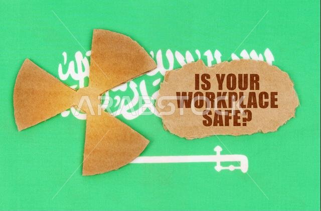 مفهوم الصناعة والإشعاع. على علم المملكة العربية السعودية، رمز النشاط الإشعاعي وقطعة من الورق المقوى الممزق مكتوب عليها: هل هذا عملك؟