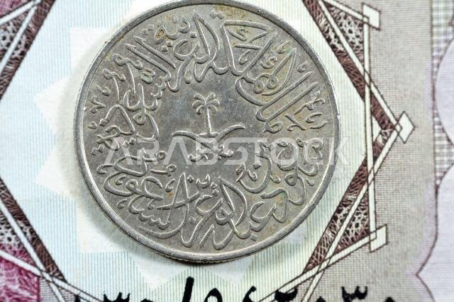 Crossed swords and palm tree at center of obverse side of old Saudi Arabia two piaster 10 ten halalah coin 1379 AH, Translation of Arabic (King Saud B Crossed swords and palm tree at center of obverse side of old Saudi Arabia two piaster 10 ten halalah coin 1379 AH, Translation of Arabic (King Saud B