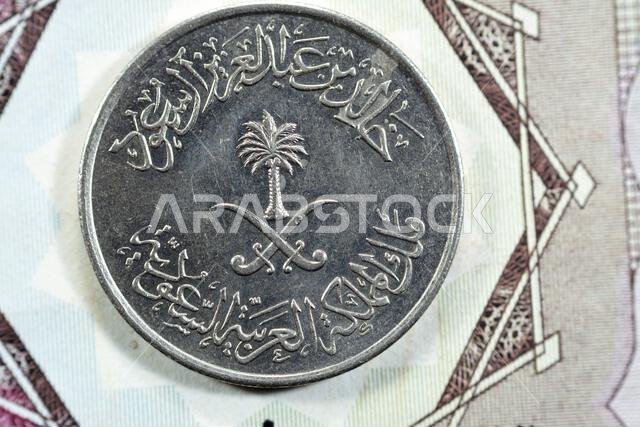 سيوف متقاطعة ونخلة في وسط وجه عملة نصف ريال سعودي قديمة من فئة 50 هلالة، صدرت عام 1400 هـ.