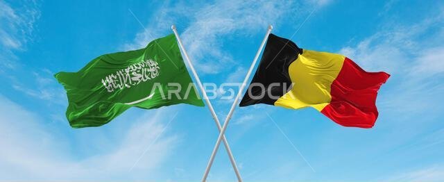 علمان متقاطعان، بلجيكا والسعودية، يرفرفان في مهب الريح تحت سماء ملبدة بالغيوم. يرمزان إلى العلاقة والحوار والسفر بين البلدين. رسم توضيحي ثلاثي الأبعاد.