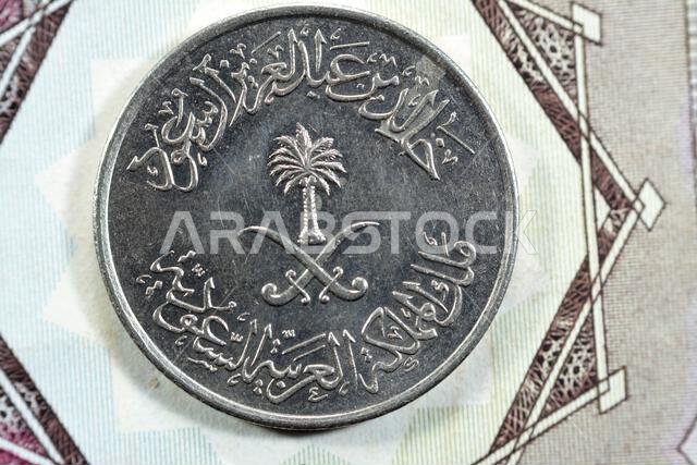 سيوف متقاطعة ونخلة في وسط وجه عملة نصف ريال سعودي قديمة من فئة 50 هلالة، صدرت عام 1400 هـ. سيوف متقاطعة ونخلة في وسط وجه عملة نصف ريال سعودي قديمة من فئة 50 هلالة، صدرت عام 1400 هـ.