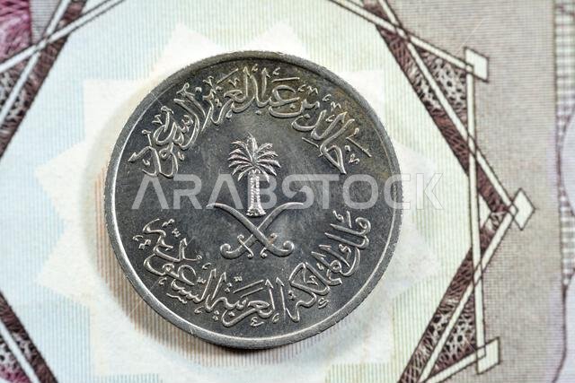 Crossed swords and palm tree at center of obverse side of old Saudi Arabia twenty five Halalah 25 halalas quarter Saudi Riyal coin 1400 AH, Translatio
