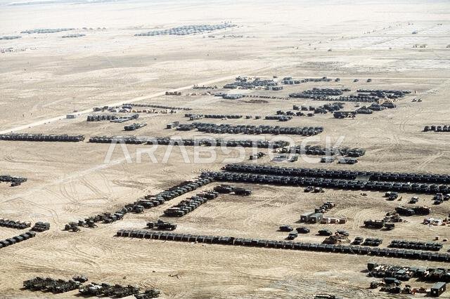 An aerial view of a vehicle park, foreground, and billeting area at the First Marine Expeditionary Force (I MEF) base camp during Operation Desert Shield.. Subject Operation/Series: DESERT SHIELD Country: Saudi Arabia(SAU)
