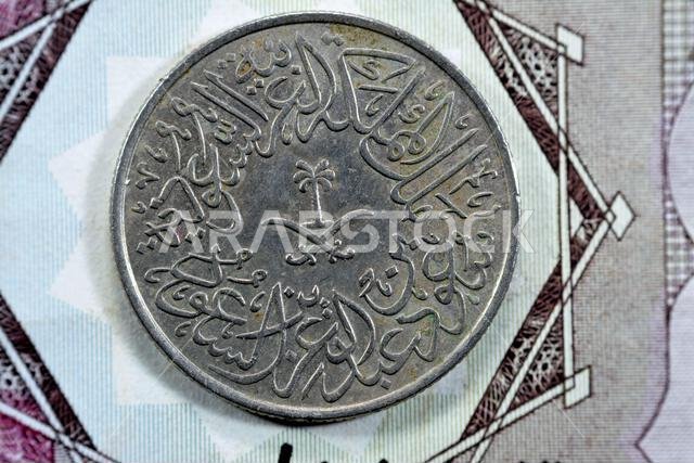 Crossed swords and palm tree at center of obverse side of old Saudi Arabia two piaster 10 ten halalah coin 1379 AH, Translation of Arabic (King Saud B