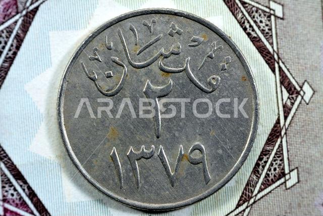 ترجمة للعبارة العربية (قرشين ١٣٧٩) من الوجه الخلفي لعملة سعودية قديمة من فئة قرش واحد (١٠ حلالة)، عملة سعودية قديمة عتيقة ترجمة للعبارة العربية (قرشين ١٣٧٩) من الوجه الخلفي لعملة سعودية قديمة من فئة قرش واحد (١٠ حلالة)، عملة سعودية قديمة عتيقة