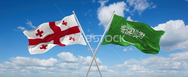 علمان متقاطعان، علم السعودية وعلم جورجيا، يرفرفان في مهب الريح تحت سماء ملبدة بالغيوم. يرمز هذا العمل الفني إلى مفهوم العلاقة والحوار والسفر بين البلدين. رسم ثلاثي الأبعاد. علمان متقاطعان، علم السعودية وعلم جورجيا، يرفرفان في مهب الريح تحت سماء ملبدة بالغيوم. يرمز هذا العمل الفني إلى مفهوم العلاقة والحوار والسفر بين البلدين. رسم ثلاثي الأبعاد.