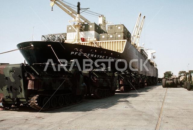 Marine AAVP-7A1 amphibious assault vehicles, forklifts and construction equipment line the pier beside the maritime pre-positioning ship PFC. Dewayne T. Williams (T-AK-3009) during Operation Desert Shield. Subject Operation/Series: DESERT SHIELD Country: Saudi Arabia (SAU) Marine AAVP-7A1 amphibious assault vehicles, forklifts and construction equipment line the pier beside the maritime pre-positioning ship PFC. Dewayne T. Williams (T-AK-3009) during Operation Desert Shield. Subject Operation/Series: DESERT SHIELD Country: Saudi Arabia (SAU)