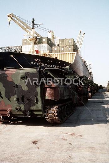 تصطف مركبات الإنزال البرمائية من طراز AAVP-7A1 التابعة للبحرية الأمريكية على الرصيف بجانب سفينة التمركز البحري PFC. Dewayne T. Williams (T-AK-3009) خلال عملية درع الصحراء. الموضوع: عملية/سلسلة: درع الصحراء، الدولة: المملكة العربية السعودية. تصطف مركبات الإنزال البرمائية من طراز AAVP-7A1 التابعة للبحرية الأمريكية على الرصيف بجانب سفينة التمركز البحري PFC. Dewayne T. Williams (T-AK-3009) خلال عملية درع الصحراء. الموضوع: عملية/سلسلة: درع الصحراء، الدولة: المملكة العربية السعودية.