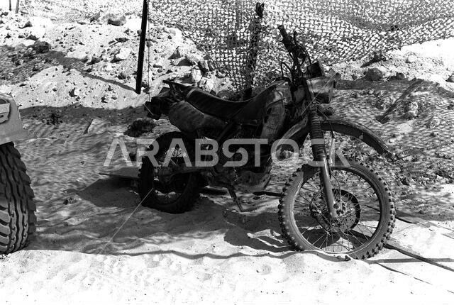A motorcycle sits beneath a camouflage net at the 1ST Battalion, 5th Marines, combat operations center (COC) during Operation Desert Shield.. Subject Operation/Series: DESERT SHIELD Country: Saudi Arabia(SAU) A motorcycle sits beneath a camouflage net at the 1ST Battalion, 5th Marines, combat operations center (COC) during Operation Desert Shield.. Subject Operation/Series: DESERT SHIELD Country: Saudi Arabia(SAU)