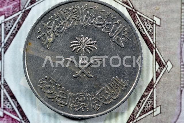 Crossed swords and palm tree at center of obverse side of old Saudi Arabia One hundred Halalah 100 halalas One Saudi Riyal coin 1396 AH, Translation o