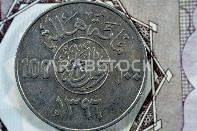 Reverse side of old Saudi Arabia One hundred Halalah, Translation (100 halalas 1 One Saudi Riyal coin series 1396 AH), Legend above inscription in cir Reverse side of old Saudi Arabia One hundred Halalah, Translation (100 halalas 1 One Saudi Riyal coin series 1396 AH), Legend above inscription in cir