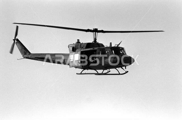صورة جانبية يمنى لمروحية من طراز UH-1N إيروكوا تابعة لسلاح مشاة البحرية الأمريكية أثناء تحليقها خلال عملية درع الصحراء. موضوع العملية/السلسلة: درع الصحراء. الدولة: المملكة العربية السعودية.