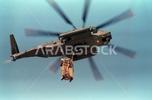 تقوم مروحية من طراز CH-53E سوبر ستاليون تابعة لسلاح مشاة البحرية الأمريكية برفع مركبة هامفي متعددة الأغراض عالية الحركة (M998) من على سطح سفينة برمائية خلال مناورة "الرعد الوشيك"، وهي مناورة استعدادية تجريها القوات العاملة في منطقة الخليج العربي دعماً لعملية "درع الصحراء". الموضوع: عملية/سلسلة: الرعد الوشيك - درع الصحراء. الدولة: المملكة العربية السعودية. تقوم مروحية من طراز CH-53E سوبر ستاليون تابعة لسلاح مشاة البحرية الأمريكية برفع مركبة هامفي متعددة الأغراض عالية الحركة (M998) من على سطح سفينة برمائية خلال مناورة "الرعد الوشيك"، وهي مناورة استعدادية تجريها القوات العاملة في منطقة الخليج العربي دعماً لعملية "درع الصحراء". الموضوع: عملية/سلسلة: الرعد الوشيك - درع الصحراء. الدولة: المملكة العربية السعودية.