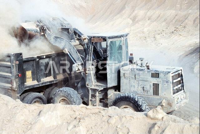 يقوم أحد أفراد كتيبة الإنشاءات البحرية المتنقلة رقم 40 (NMCB-40) بتفريغ جرافة التحميل الأمامية في مؤخرة شاحنة قلابة أثناء حفر حفرة لنقطة إمداد بالذخيرة خلال عملية درع الصحراء. الموضوع: عملية/سلسلة: درع الصحراء، الدولة: المملكة العربية السعودية. يقوم أحد أفراد كتيبة الإنشاءات البحرية المتنقلة رقم 40 (NMCB-40) بتفريغ جرافة التحميل الأمامية في مؤخرة شاحنة قلابة أثناء حفر حفرة لنقطة إمداد بالذخيرة خلال عملية درع الصحراء. الموضوع: عملية/سلسلة: درع الصحراء، الدولة: المملكة العربية السعودية.