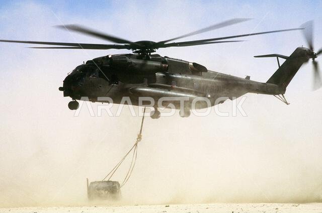 A CH-53E Super Stallion helicopter lowers an M-998 high-mobility multipurpose wheeled vehicle into a landing zone during Exercise Imminent Thunder, part of Operation Desert Shield.. Subject Operation/Series: IMMINENT THUNDERDESERT SHIELD Country: Saudi Arabia(SAU)