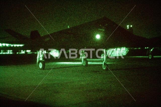 كما يظهر من خلال عدسة الرؤية الليلية، تقف طائرة من طراز إف-117إيه تابعة للجناح المقاتل التكتيكي السابع والثلاثين على مدرج الطائرات خلال عملية درع الصحراء. العملية/السلسلة: درع الصحراء. الدولة: المملكة العربية السعودية. كما يظهر من خلال عدسة الرؤية الليلية، تقف طائرة من طراز إف-117إيه تابعة للجناح المقاتل التكتيكي السابع والثلاثين على مدرج الطائرات خلال عملية درع الصحراء. العملية/السلسلة: درع الصحراء. الدولة: المملكة العربية السعودية.