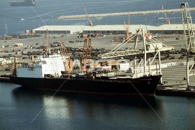 The vehicle cargo ship MAJ. STEPHEN W. PLESS (T-AK-3007) of Maritime Pre-positioning Ship Squadron 1 offloads cargo during Operation Desert Shield.. Subject Operation/Series: DESERT SHIELD Base: Jubail Country: Saudi Arabia(SAU)