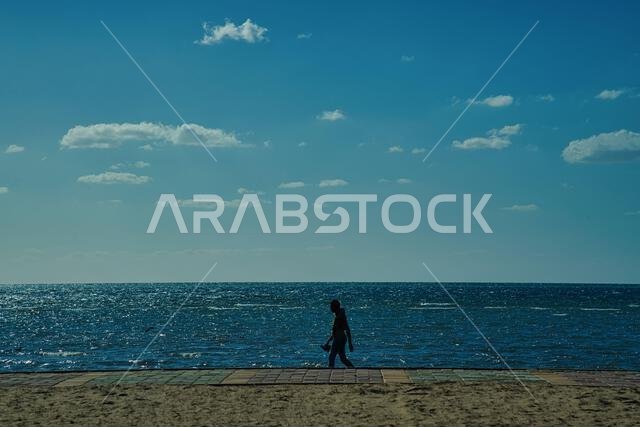 man walking through the beach in sunny day
