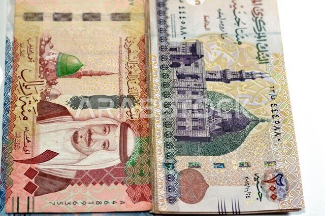 One hundred Saudi Arabia riyals cash money banknote 100 SAR features king Salman and the prophet mosque with 200 LE EGP two hundred Egyptian pounds fe One hundred Saudi Arabia riyals cash money banknote 100 SAR features king Salman and the prophet mosque with 200 LE EGP two hundred Egyptian pounds fe