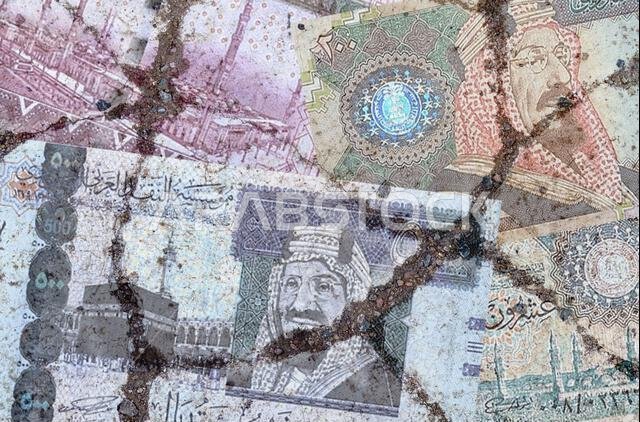 Business and finance concept. On the cracked asphalt there is an image of the Saudi rial.