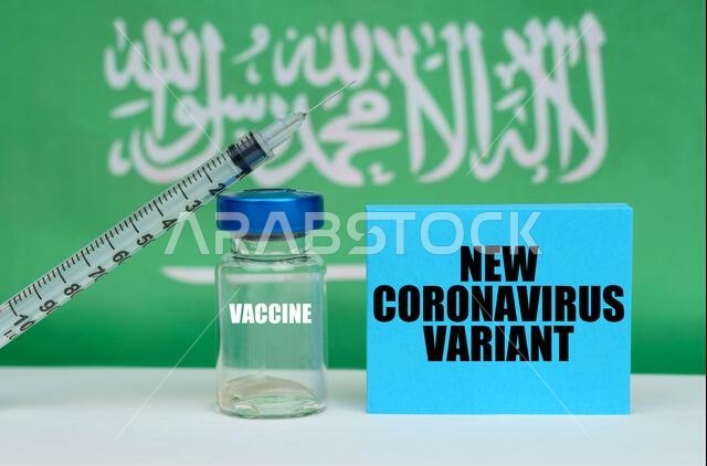 مفهوم طبي. لقاح، حقنة، ولوحة زرقاء مكتوب عليها: "متحور جديد من فيروس كورونا". في الخلفية علم المملكة العربية السعودية