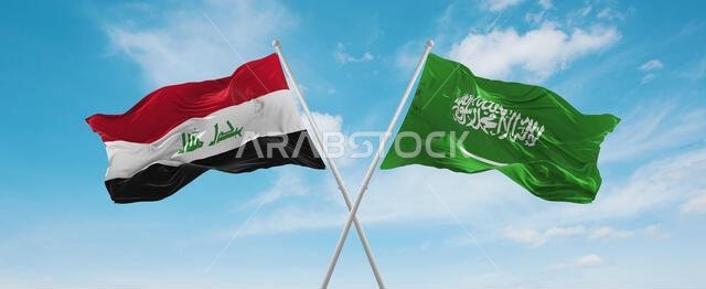 علمان متقاطعان، علم السعودية وعلم العراق، يرفرفان في مهب الريح تحت سماء ملبدة بالغيوم. يرمز هذا إلى مفهوم العلاقة والحوار والسفر بين البلدين. رسم توضيحي ثلاثي الأبعاد.