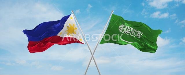 علمان متقاطعان، علم السعودية وعلم الفلبين، يرفرفان في مهب الريح تحت سماء ملبدة بالغيوم. يرمز هذا العمل الفني إلى مفهوم العلاقة والحوار والسفر بين البلدين. رسم ثلاثي الأبعاد