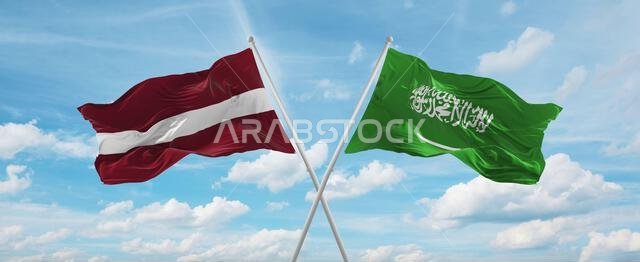 two crossed flags Saudi Arabia and Latvia waving in wind at cloudy sky. Concept of relationship, dialog, travelling between two countries. 3d illustra