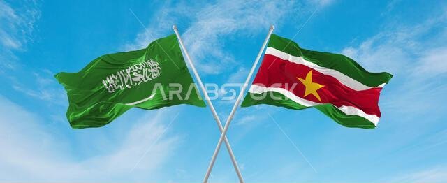 علمان متقاطعان، علم سورينام وعلم السعودية، يرفرفان في مهب الريح تحت سماء ملبدة بالغيوم. يرمز هذا العمل الفني إلى مفهوم العلاقة والحوار والسفر بين البلدين. رسم ثلاثي الأبعاد.