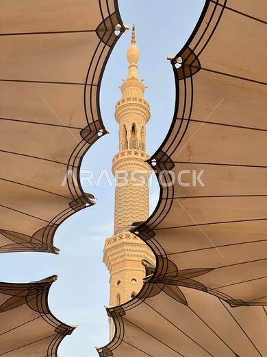 A vertical low-angle shot from under Shading Umbrellas of Medina Haram Piazza