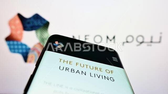 Mobile phone with website of Saudi Arabian property developer NEOM Company on screen in front of logo. Focus on top-left of phone display. Mobile phone with website of Saudi Arabian property developer NEOM Company on screen in front of logo. Focus on top-left of phone display.