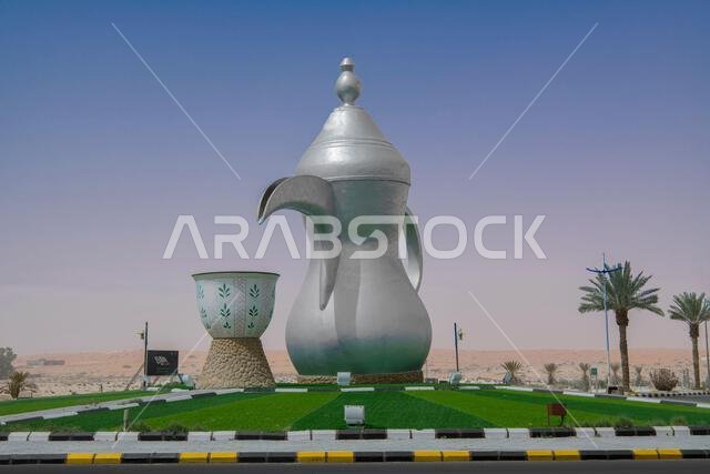 إبريق شاي وكوب فضيان عربيان مزخرفان عملاقان على دوار في جبة، المملكة العربية السعودية إبريق شاي وكوب فضيان عربيان مزخرفان عملاقان على دوار في جبة، المملكة العربية السعودية