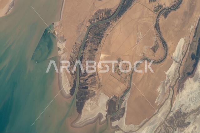 The Arvand Roud River forms part of the border between Iraq and Iran and flows into the Persian Gulf. The Bahmanshir River in Iran also drains into the Persian Gulf. This image was taken from the International Space Station orbiting 262 miles above Saudi Arabia near Bahrain.