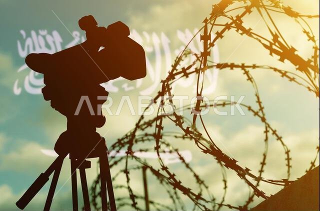 مفهوم حرية التعبير والديمقراطية. تعريض مزدوج - كاميرا، أسلاك شائكة، وعلم المملكة العربية السعودية مفهوم حرية التعبير والديمقراطية. تعريض مزدوج - كاميرا، أسلاك شائكة، وعلم المملكة العربية السعودية