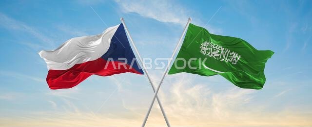 علمان متقاطعان، علم المملكة العربية السعودية وعلم جمهورية التشيك، يرفرفان في مهب الريح تحت سماء ملبدة بالغيوم. يرمز هذا العمل الفني إلى مفهوم العلاقة والحوار والسفر بين البلدين. ثلاثي الأبعاد