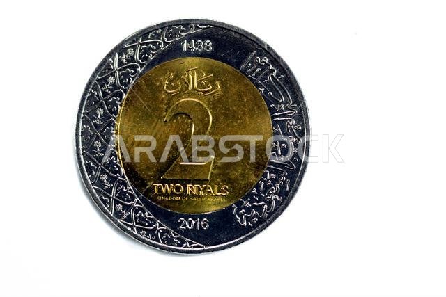 الوجه الخلفي لعملة معدنية من فئة ريالين سعوديين، إصدار عام 1438 هـ/2016م، يحمل شعارات نبالة متعددة ضمن الزخارف النباتية ونقشًا لـ الوجه الخلفي لعملة معدنية من فئة ريالين سعوديين، إصدار عام 1438 هـ/2016م، يحمل شعارات نبالة متعددة ضمن الزخارف النباتية ونقشًا لـ