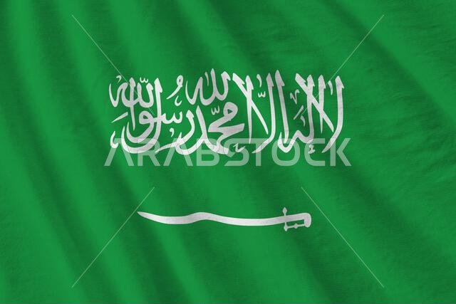 Saudi Arabia flag with big folds waving close up under the studio light indoors. The official symbols and colors in fabric banner