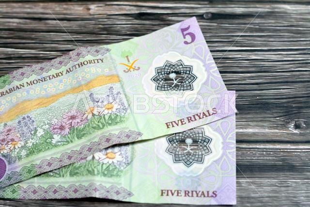 Reverse side of the new polymer 5 SAR five Saudi Arabia riyals cash money banknote bill series 1441 AH 2020 features a field of flowers, selective foc Reverse side of the new polymer 5 SAR five Saudi Arabia riyals cash money banknote bill series 1441 AH 2020 features a field of flowers, selective foc