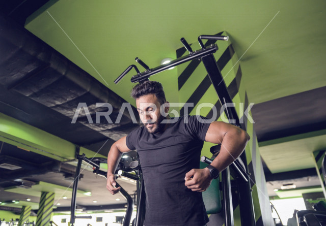 شاب سعودي رياضي يقوم بتمرين العقلة  السحب للأعلى في النادي