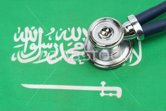 مفهوم الطب والاقتصاد. يوجد سماعة طبية على علم المملكة العربية السعودية. مفهوم الطب والاقتصاد. يوجد سماعة طبية على علم المملكة العربية السعودية.
