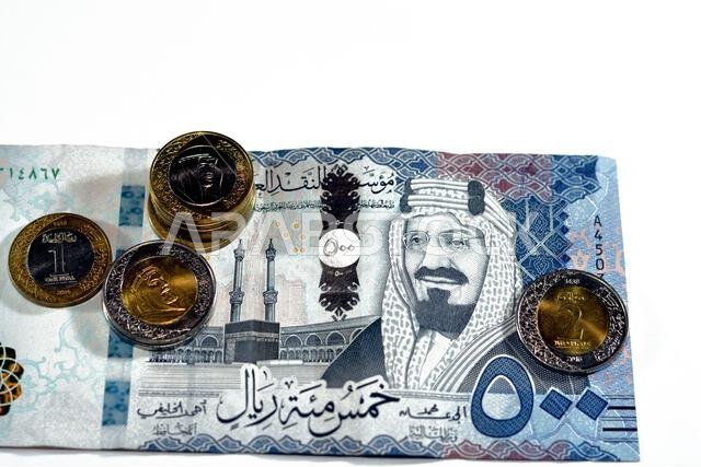 500 SAR five hundred Saudi Arabia riyals cash money banknote with pile of Saudi riyal coins 1 and 2 riyals features king Salman Bin AbdulAziz Al Saud