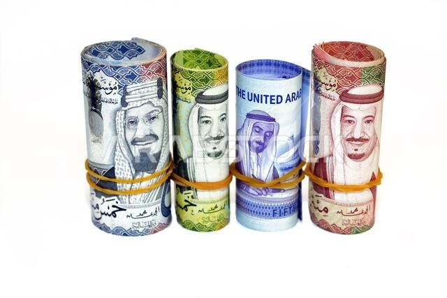 لفائف من الأوراق النقدية من فئة 50 ريالاً سعودياً، و50 درهماً إماراتياً، و500 ريالاً، و100 ريال. لفائف من الأوراق النقدية من فئة 50 ريالاً سعودياً، و50 درهماً إماراتياً، و500 ريالاً، و100 ريال.