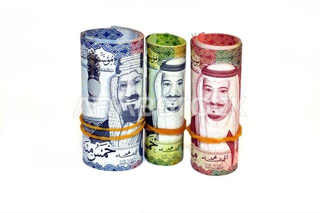 لفائف من الأوراق النقدية، تحتوي كل لفة على 500 ورقة نقدية من فئة 500 ريال سعودي، و100 ورقة نقدية من فئة 100 ريال، و50 ورقة نقدية من فئة 50 ريال، ملفوفة بشريط مطاطي.