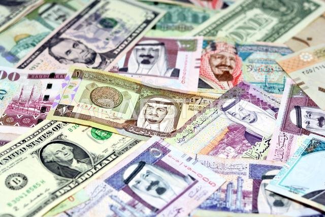 أوراق نقدية من الريال السعودي مع أوراق نقدية من الدولار الأمريكي، تركيز انتقائي على الريال السعودي، ودولار الولايات المتحدة الأمريكية