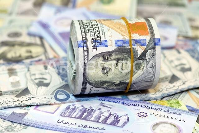 لفة نقود أمريكية عليها شريط، وكومة من أوراق الدولار الأمريكي، وأوراق نقدية أمريكية مع أوراق نقدية من الريال السعودي والإمارات الجديدة. لفة نقود أمريكية عليها شريط، وكومة من أوراق الدولار الأمريكي، وأوراق نقدية أمريكية مع أوراق نقدية من الريال السعودي والإمارات الجديدة.