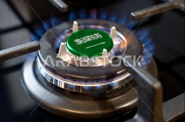 Gas import and export concept. A burning gas burner of a home stove, in the middle of which a flag is depicted - Saudi Arabia