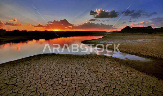 صورة لجفاف وشح المياه في المملكة العربية السعودية وقت غروب الشمس، مناظر طبيعية خلابة، غروب الشمس، تشققات التربة، الجفاف والتصحر، الجفاف و شح المياه، جفاف مناخي، الاحتباس الحراري، السياحة في السعودية