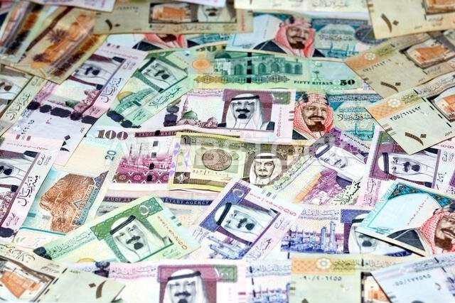 خلفية لمجموعة من الأوراق النقدية من فئة الريال السعودي، بقيم مختلفة ومن فترات زمنية مختلفة، مع تركيز انتقائي على كومة من الريالات السعودية خلفية لمجموعة من الأوراق النقدية من فئة الريال السعودي، بقيم مختلفة ومن فترات زمنية مختلفة، مع تركيز انتقائي على كومة من الريالات السعودية